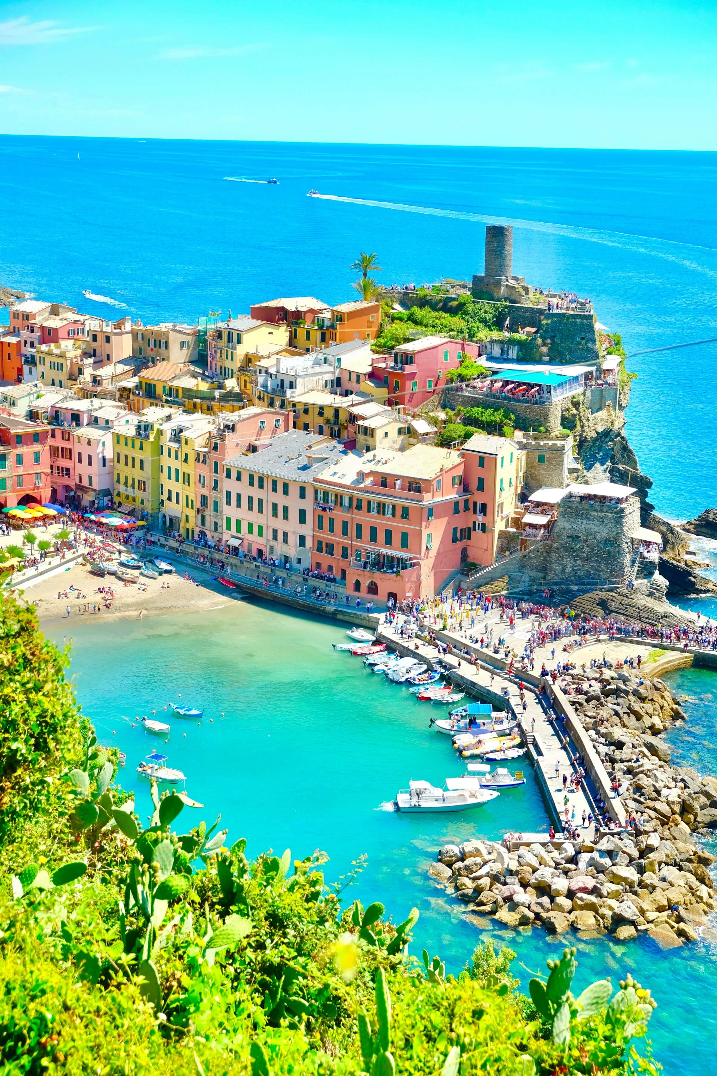 Colourful houses along a coastal town with boats in the harbour